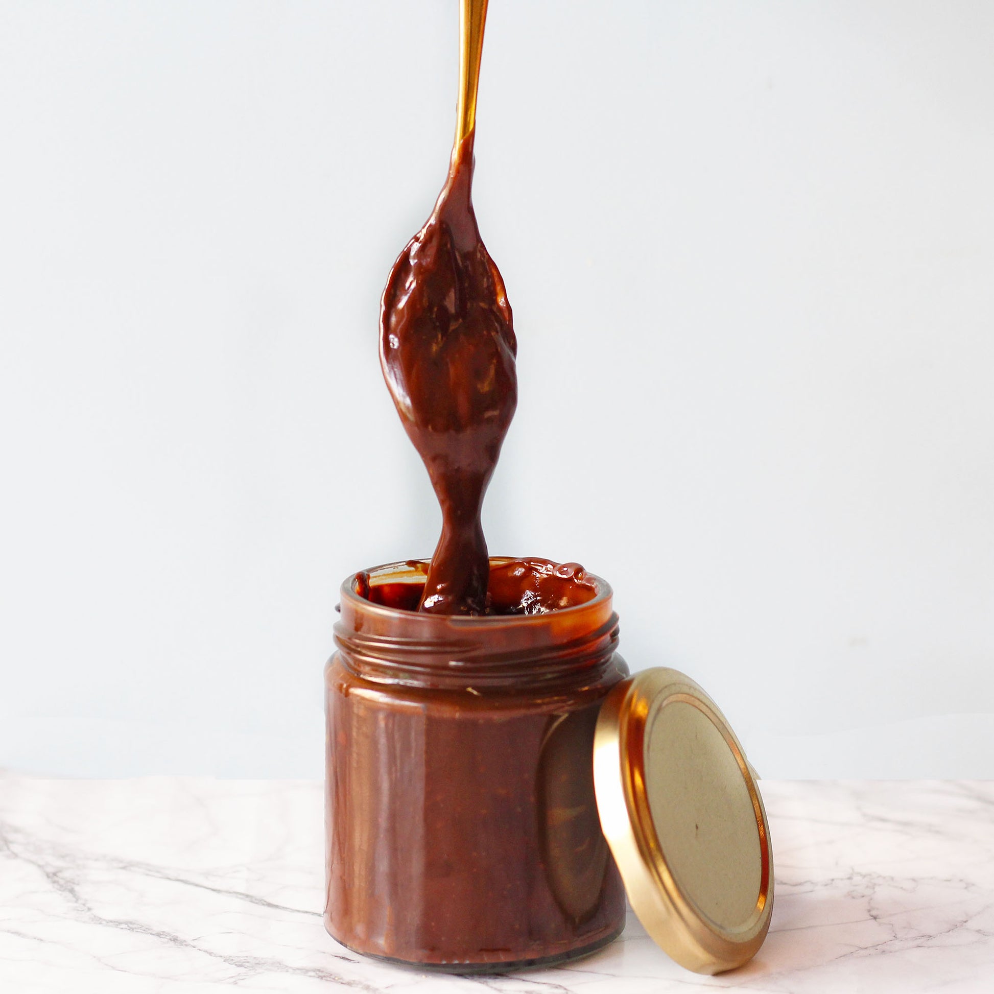 chocolate spread jar with spoon dipped in